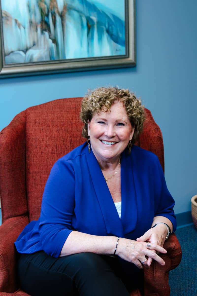 Dr. Denise sitting in chair ready to work with parents and families